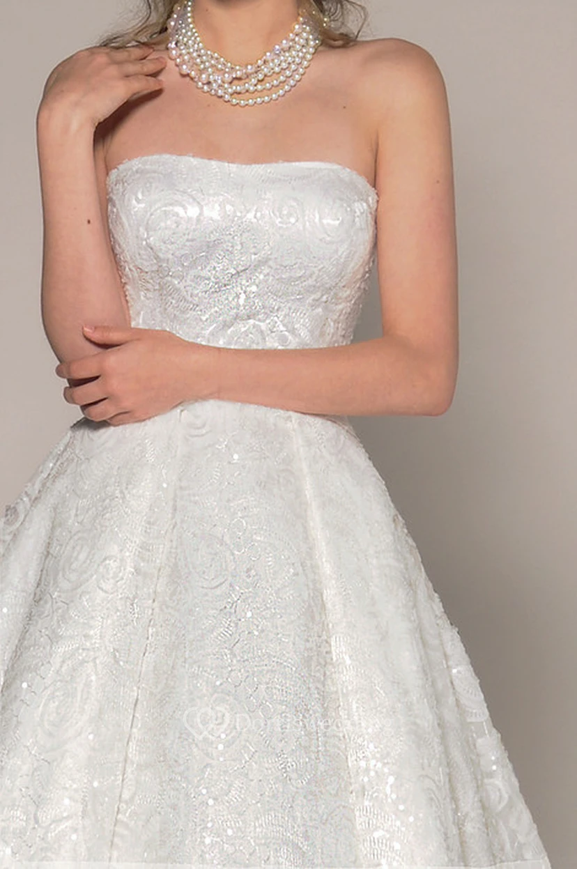 Vestido de novia asimétrico sin tirantes con encaje y pedrería en la espalda en V. view 3