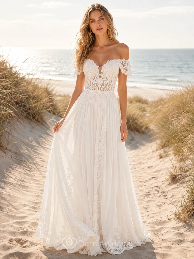 Robe de mariée bohème en dentelle florale, épaules dénudées, décolleté cœur, manches courtes illusion, coupe trapèze et traîne.
