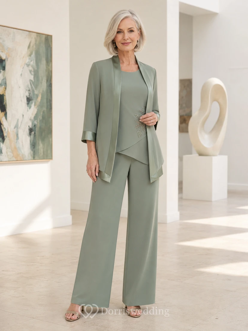 Salbeigrüner, moderner Hosenanzug für die Mutter der Braut mit weitem Bein, asymmetrischem Dreiviertel-Jäckchen mit Rundhalsausschnitt, Satinbesatz und Palazzo-Hose.