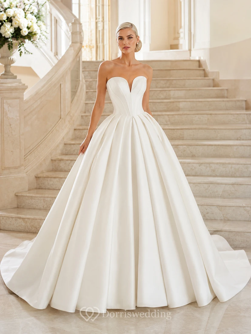 Robe de bal bustier en satin harmonieux, décolleté cœur, traîne cathédrale et plis, idéale pour un mariage à destination.