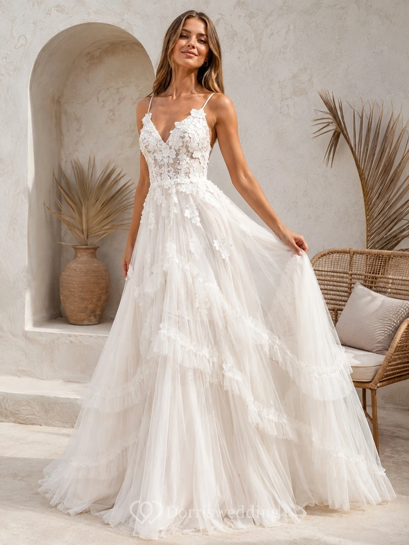 Vestido de gala blanco de tul con escote corazón, sin mangas, largo hasta el suelo, con volantes escalonados.
