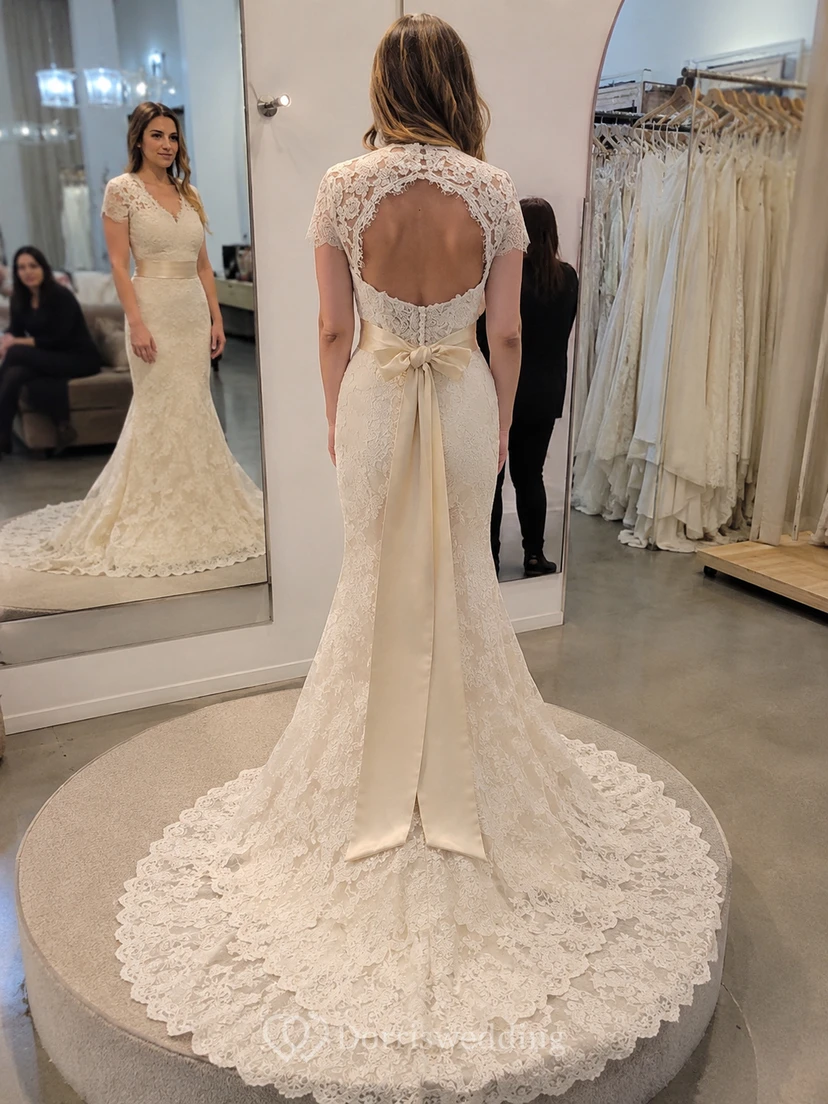 Robe de mariée sirène vintage en dentelle, décolleté en V, dos nu en forme de goutte, avec ceinture et fleur. view 6