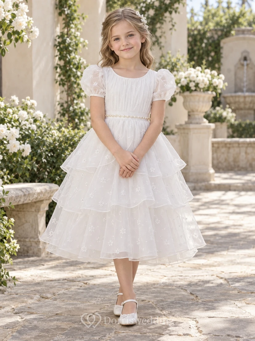 Vestido de niña de flores modesto, blanco, de corte A, de tul, con mangas abullonadas y pliegues, hasta la rodilla.