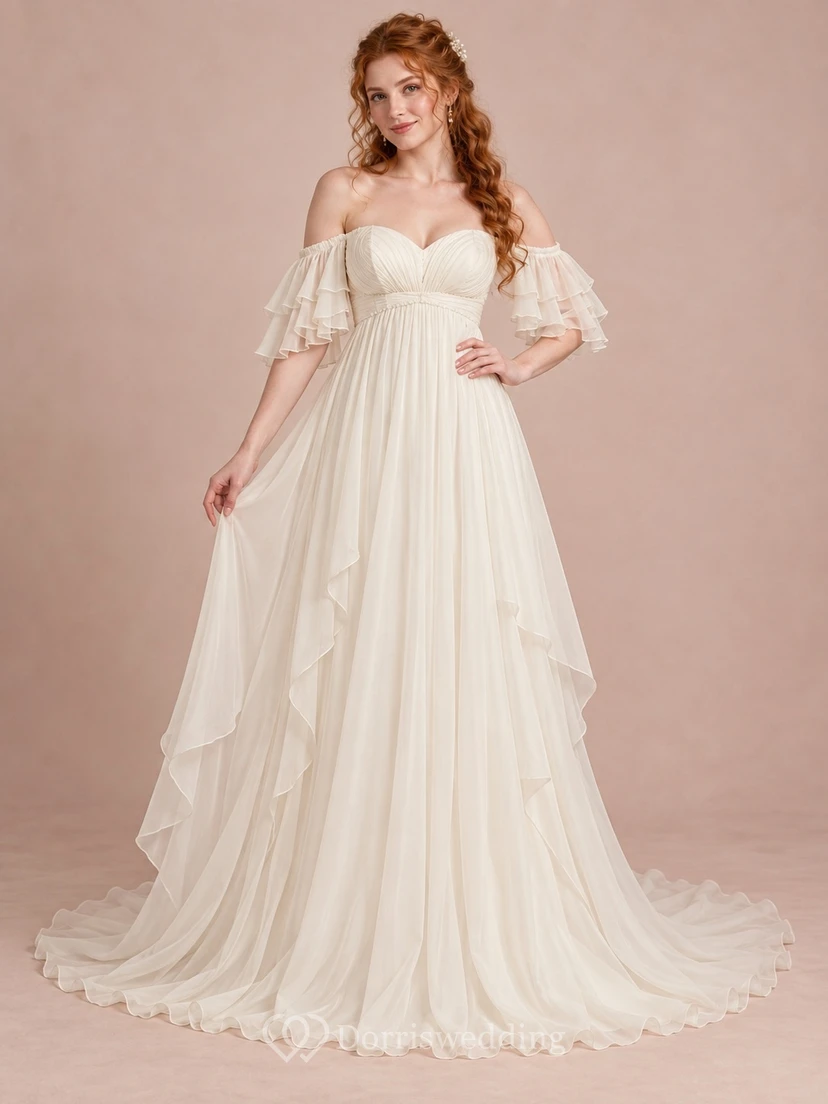 Vestido de novia largo estilo imperio con escote corazón, mangas superpuestas, gasa fruncida y caída en cascada.