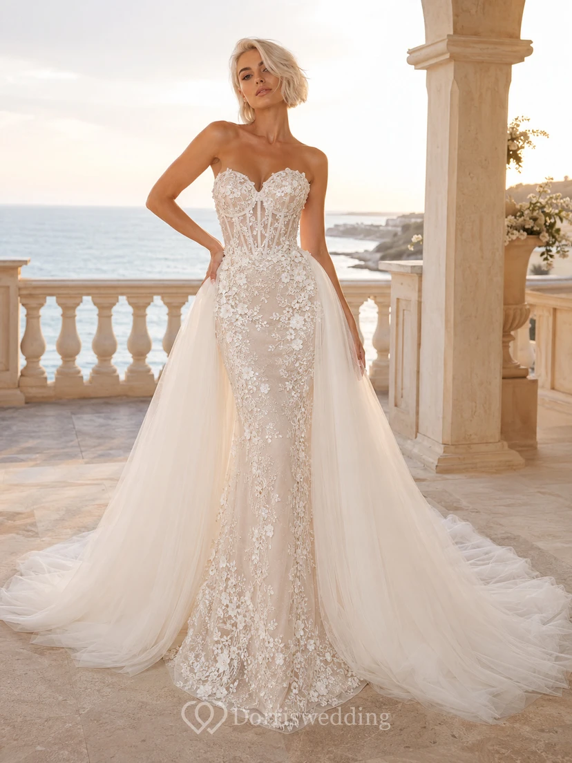 Robe de mariée sirène bustier en dentelle et tulle lumineux, décolleté cœur, traîne cathédrale et jupe amovible, idéale pour un mariage à destination.