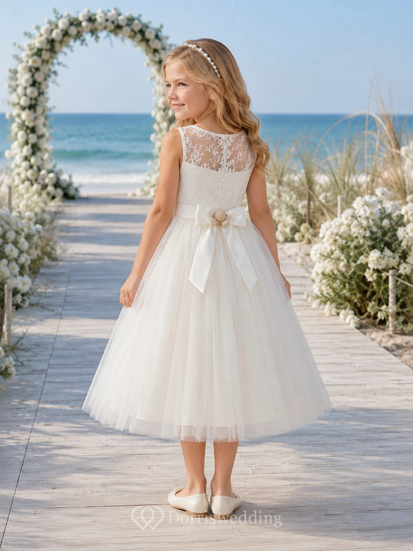 Elegante vestido de niña de las flores con corte en A, corpiño de encaje, falda de tul y lazo en la cintura para ceremonia en la playa. view 2