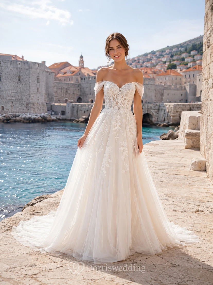 Robe de mariée romantique en dentelle et tulle, épaules dénudées, coupe trapèze, pour une destination au bord de l'eau