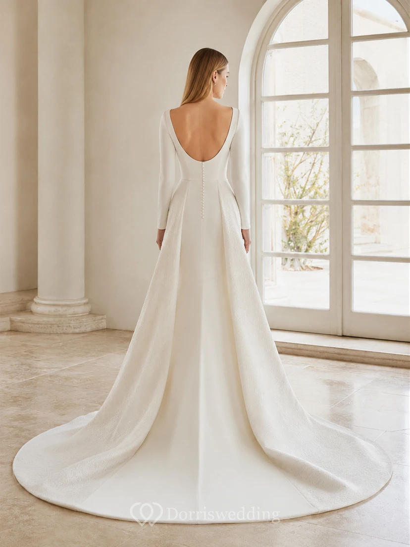 Robe de mariée minimaliste en satin poli, col bateau, manches longues cintrées, fourreau et traîne courte. view 2