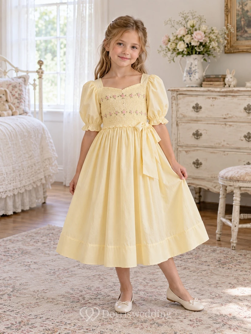 Vestido de niña de flores amarillo de corte A, largo hasta la rodilla, escote cuadrado, mangas abullonadas, corpiño bordado y bajo fruncido con banda.
