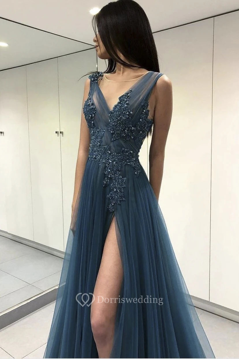 Vestido largo hasta el suelo con escote en V, tul etéreo, abertura frontal, apliques y abalorios.
