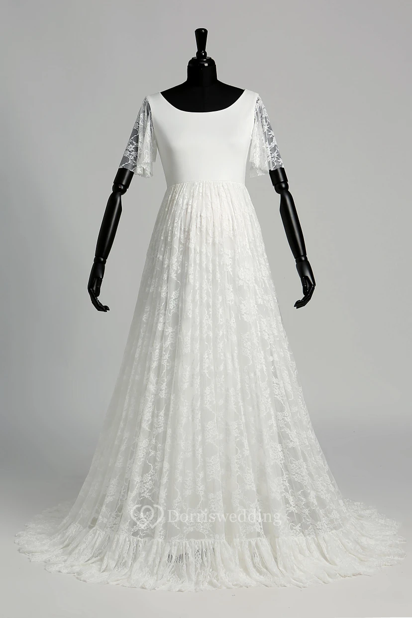 Robe de mariée en satin et dentelle, coupe trapèze, décolleté en V, manches courtes illusion, traîne courte.