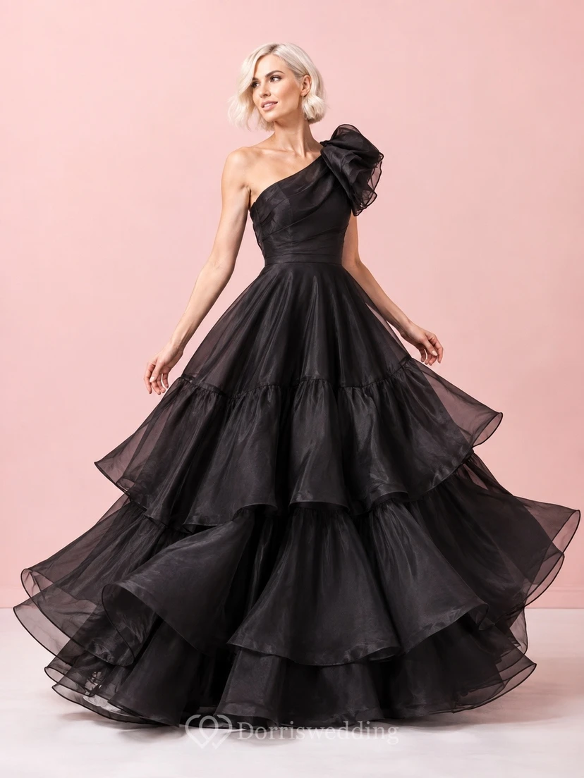 Vestido de gala negro de tul con un solo hombro, sin mangas y con volantes.