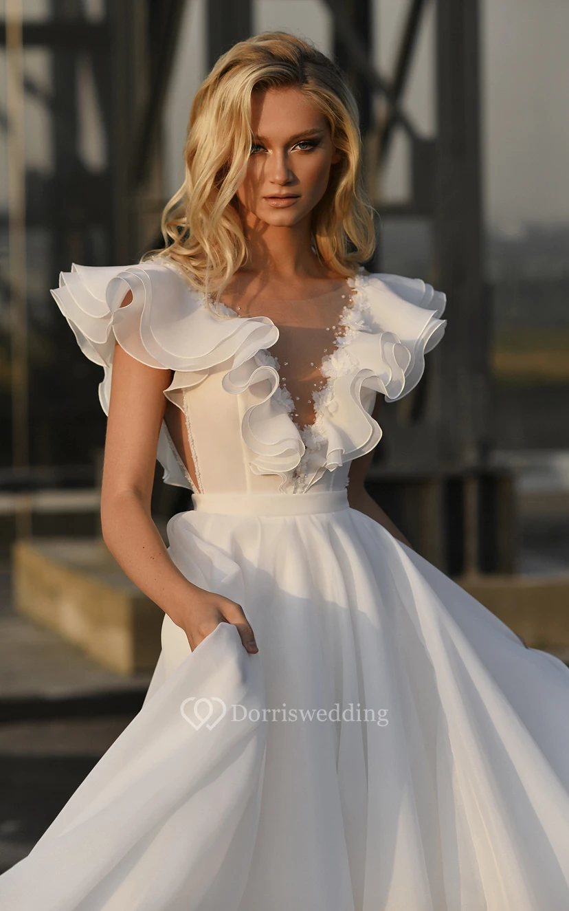 Robe de mariée vintage en mousseline de soie, manches bouffantes, traîne courte, ornée de perles et de volants, coupe bal. view 3