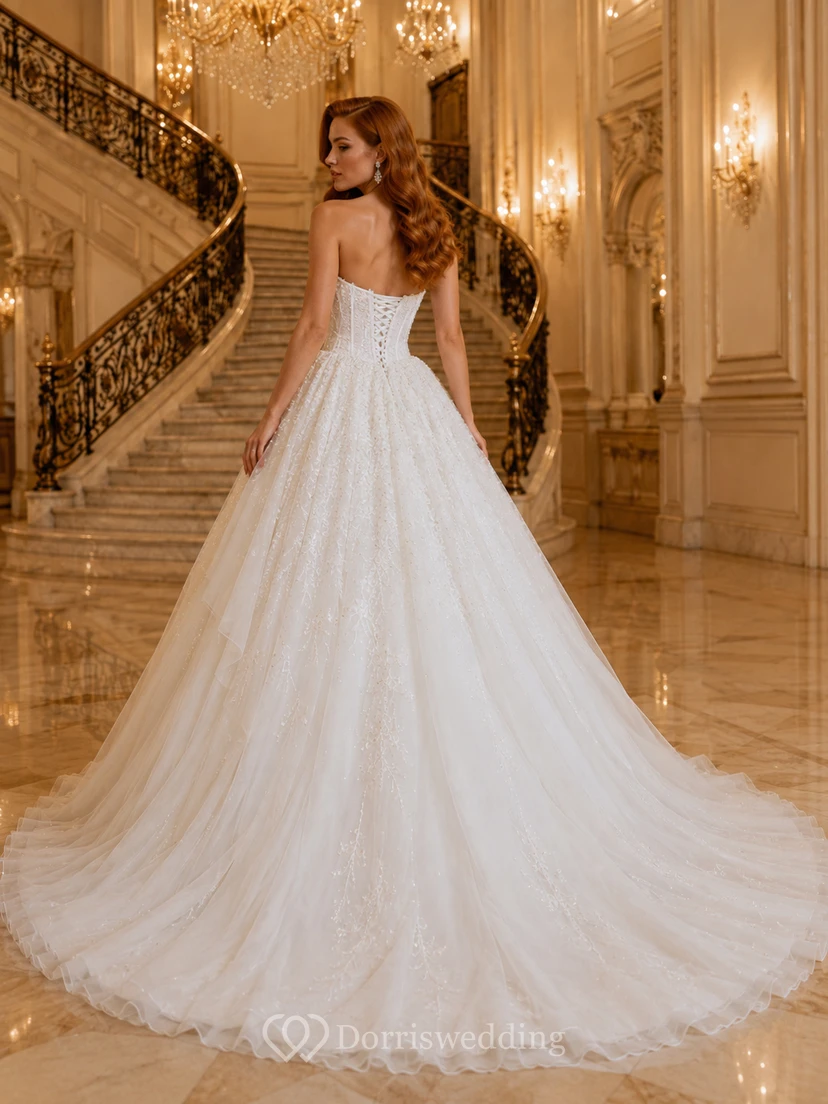 Vestido de novia de tul, estilo princesa, sin tirantes, con cola larga, detalle de volantes y escote en V en la espalda. view 2