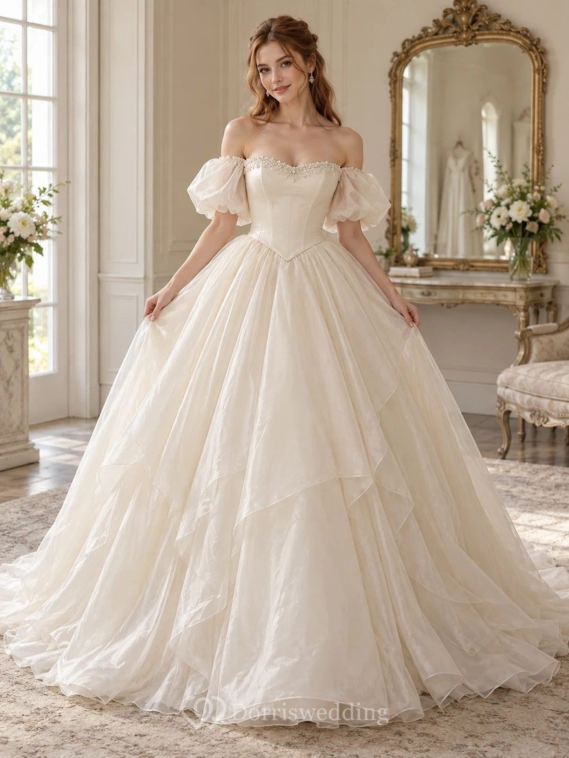 Schulterfreies Brautkleid aus Spitze mit Puffärmeln, asymmetrischem Lagenrock und Organza