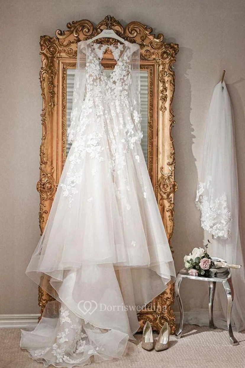 Vestido de novia de corte A con escote en V, mangas largas, efecto ilusión y apliques de encaje.