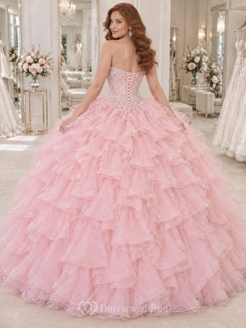 Vestido de novia de gala rosa palo sin tirantes con escote corazón, bordado con cuentas y volantes de organza en cascada. view 2