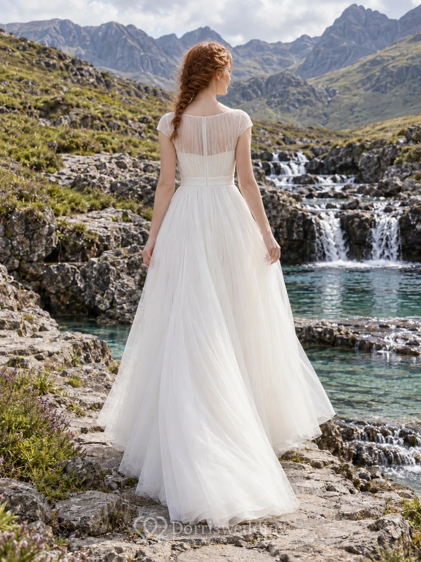 Sencillo vestido de novia de tul con corte en A, escote ilusión tipo barco y mangas cortas transparentes. view 2
