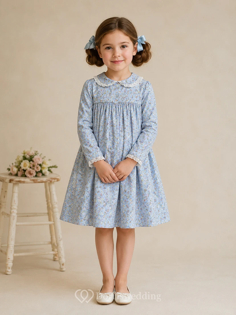 Robe de demoiselle d'honneur bleu ciel en mousseline, coupe trapèze, manches longues simples, encolure bijou et jupe longueur genou à plis souples.