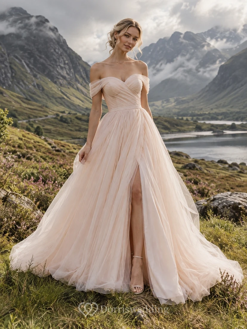 Vestido de novia de tul rosa empolvado con hombros descubiertos, corpiño fruncido y abertura frontal.
