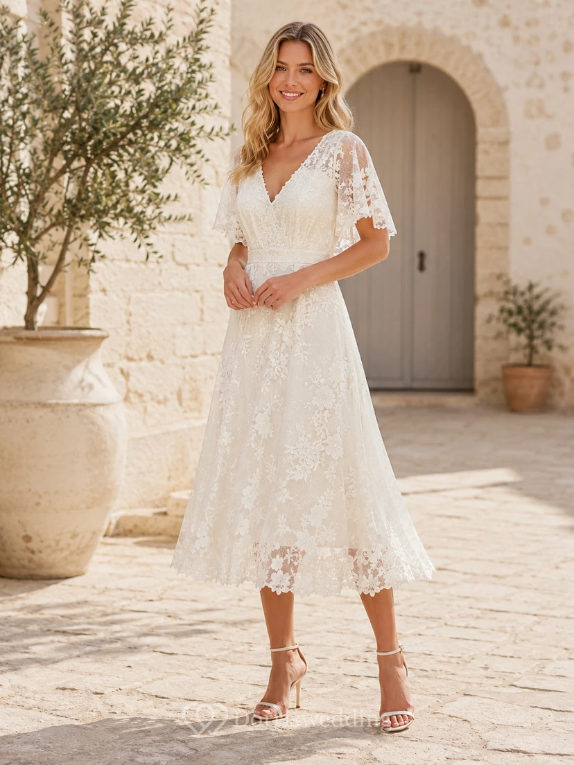 Vestido de invitada color marfil con escote en V, manga corta, encaje, espalda baja, corte en A y largo hasta la rodilla.
