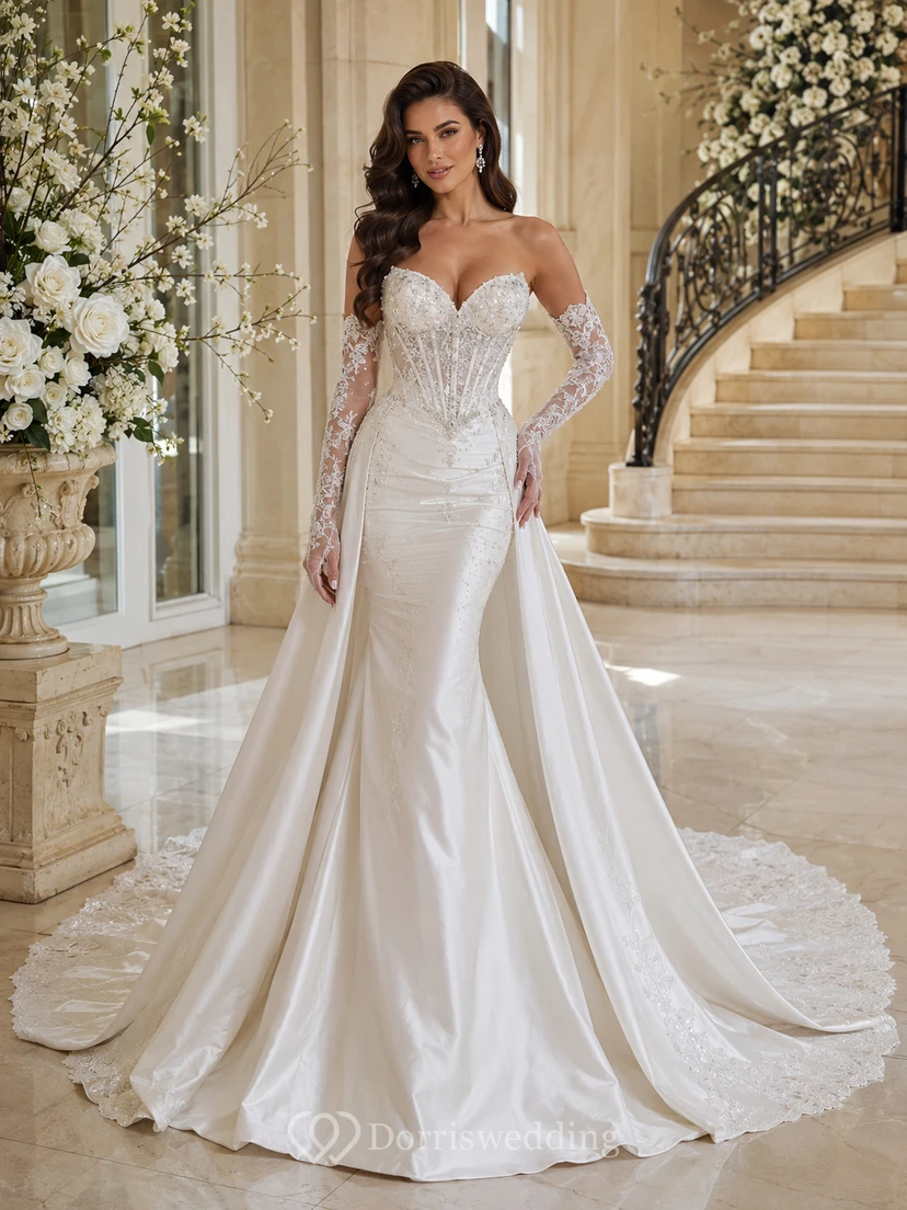 Robe de mariée sirène en satin immaculé et dentelle, décolleté cœur, manches longues transparentes, traîne cathédrale, jupe amovible, robe de bal