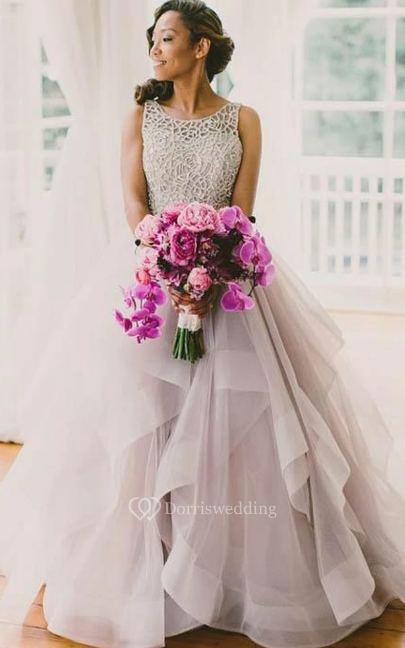 Vestido de tul sin mangas con corte en A, cola larga y volantes.