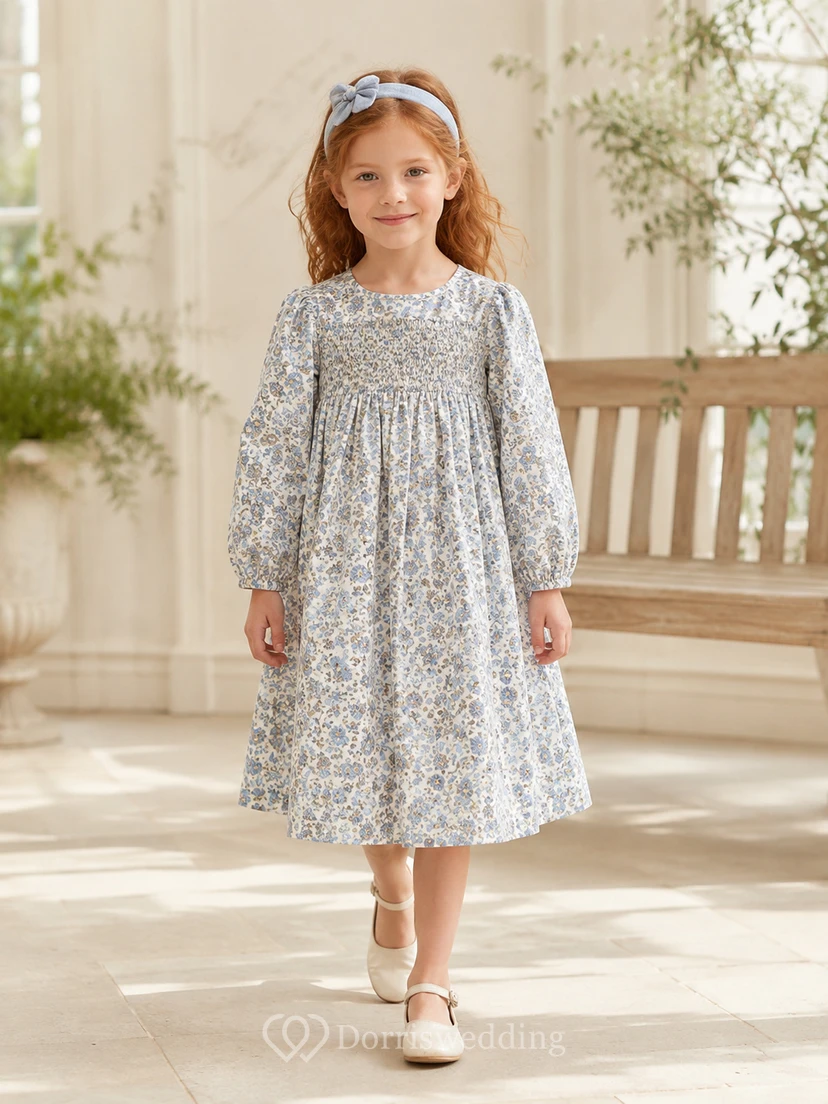 Robe de demoiselle d'honneur bleu acier en mousseline, coupe trapèze, manches longues simples, encolure bijou et jupe longueur genou à plis souples.
