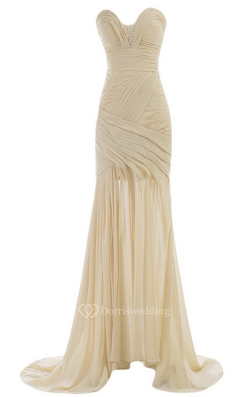 Vestido de novia con escote corazón, cola larga, fruncido y abalorios.