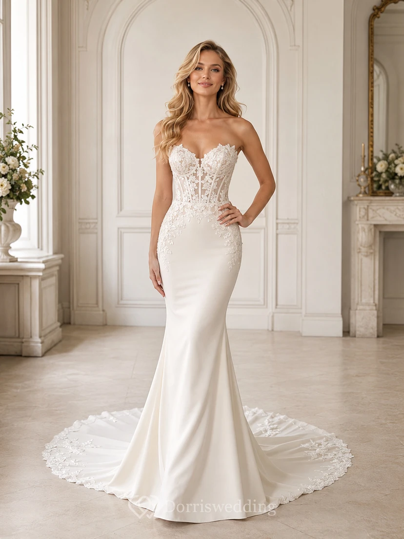 Robe de mariée sirène en satin et dentelle vaporeux, bustier cœur sans manches, traîne chapelle, ornée d'appliqués floraux.