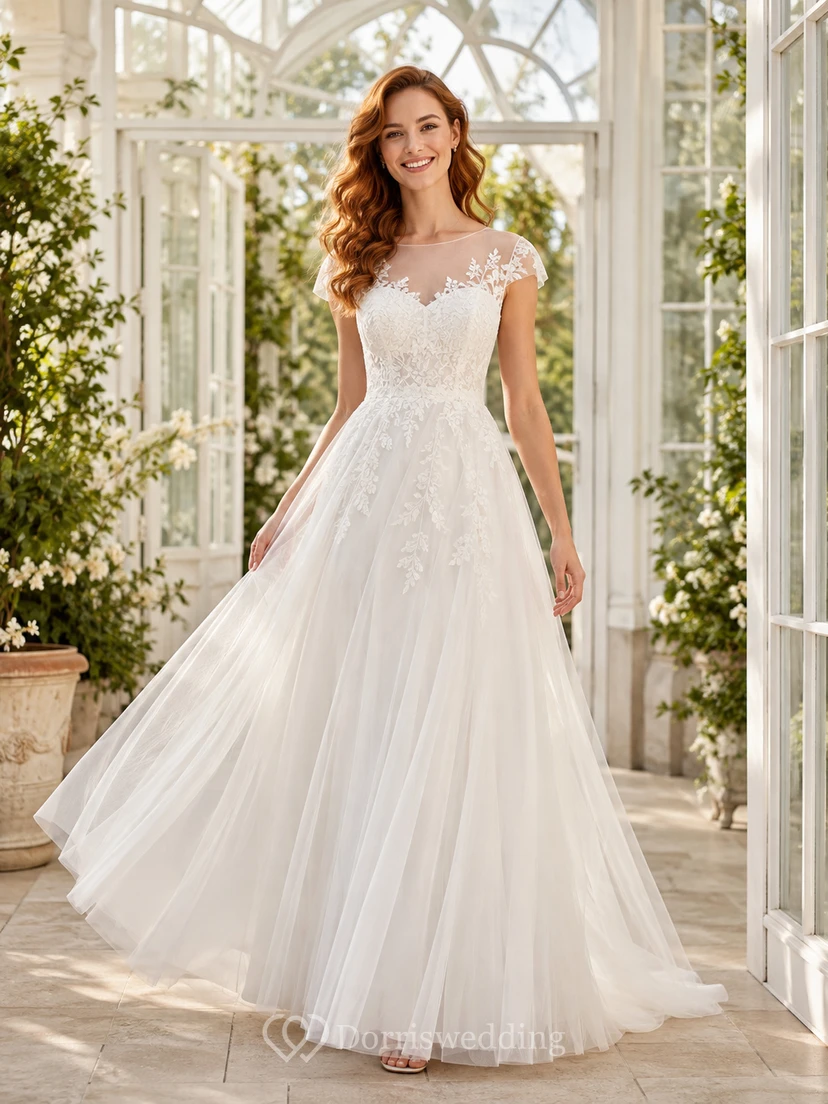 Robe de mariée romantique coupe A, décolleté bateau, dentelle illusion, manches courtes, style chapelle, idéale pour un jardin.