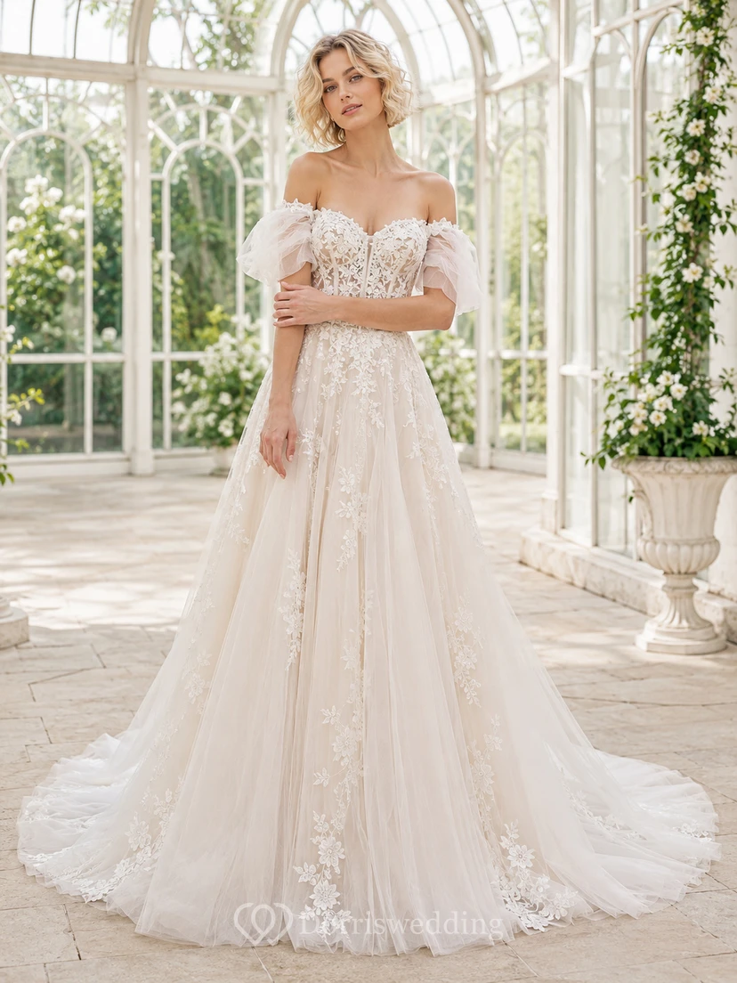 Robe de mariée élégante en dentelle et tulle, épaules dénudées, manches courtes, coupe trapèze, traîne chapelle, ornée d'appliqués floraux, au bord d'un lac