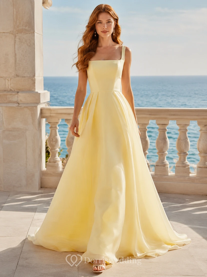 Vestido de novia de organza color amarillo narciso con escote cuadrado, corte en A y cola de capilla, ideal para bodas en jardines.
