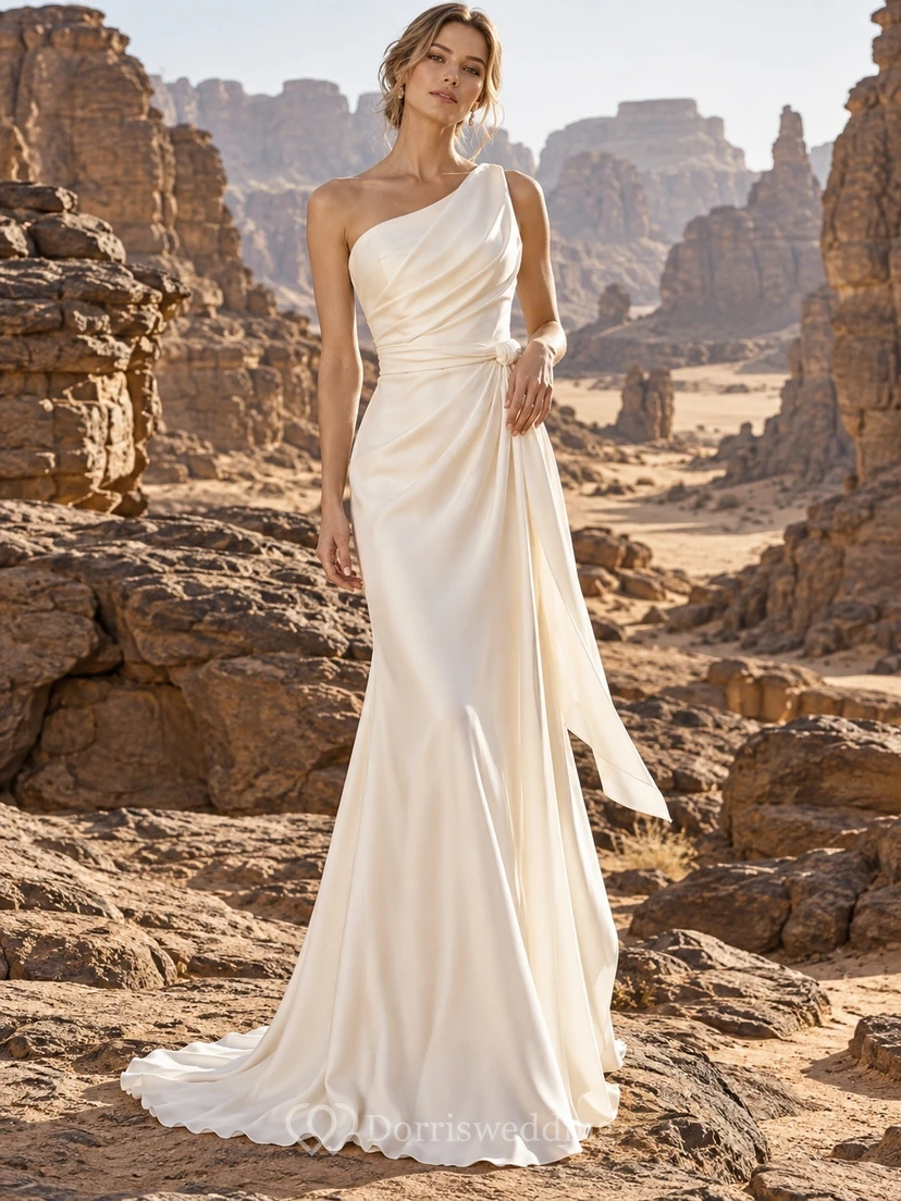Vestido de novia sencillo de satén con un solo hombro, corpiño drapeado, fajín anudado y cola.