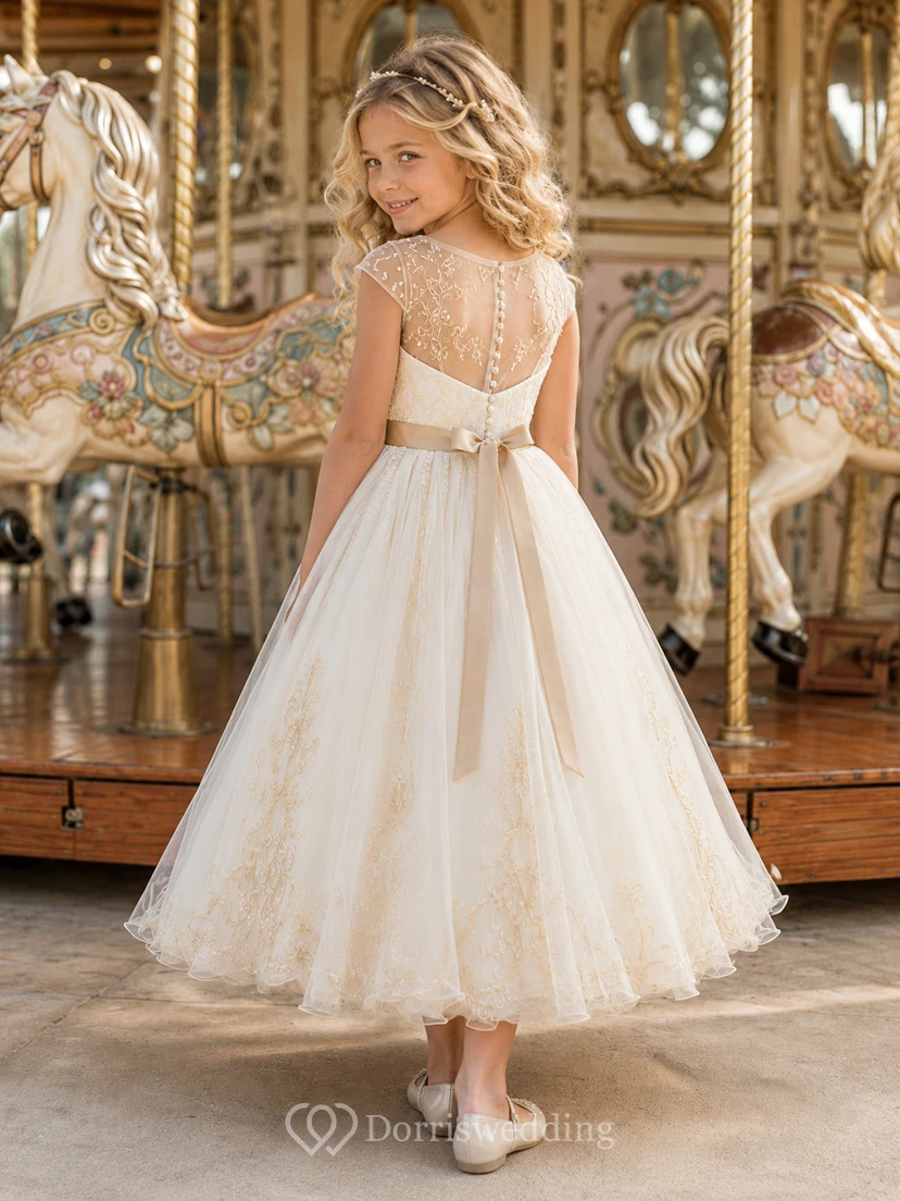 Vestido de niña de las flores color marfil con mangas cortas transparentes, corpiño con escote corazón, falda de tul en línea A hasta la rodilla y lazo bordado dorado en la cintura. view 2