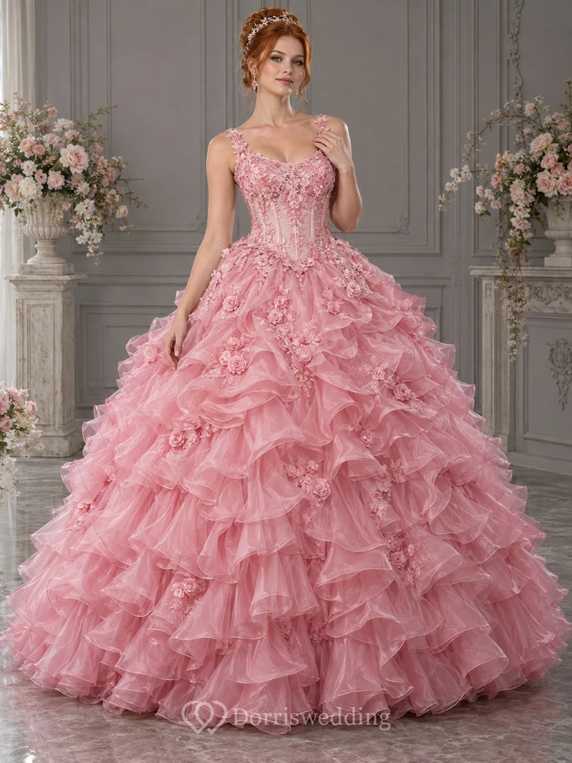 Vestido de novia de gala color rosa empolvado con escote redondo y tirantes florales, adornado con cascadas de organza cubiertas de rosas.