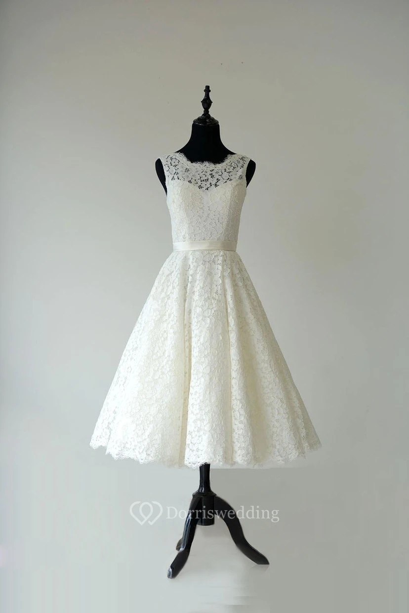 Robe en dentelle sans manches, coupe trapèze, longueur thé, dos nu en V et ceinture en satin.